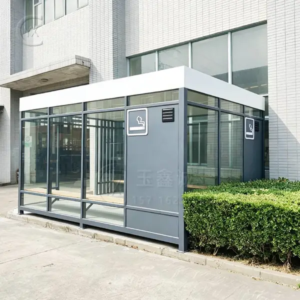 户外吸烟亭采用钢化玻璃与金属框架结构外观简洁耐用